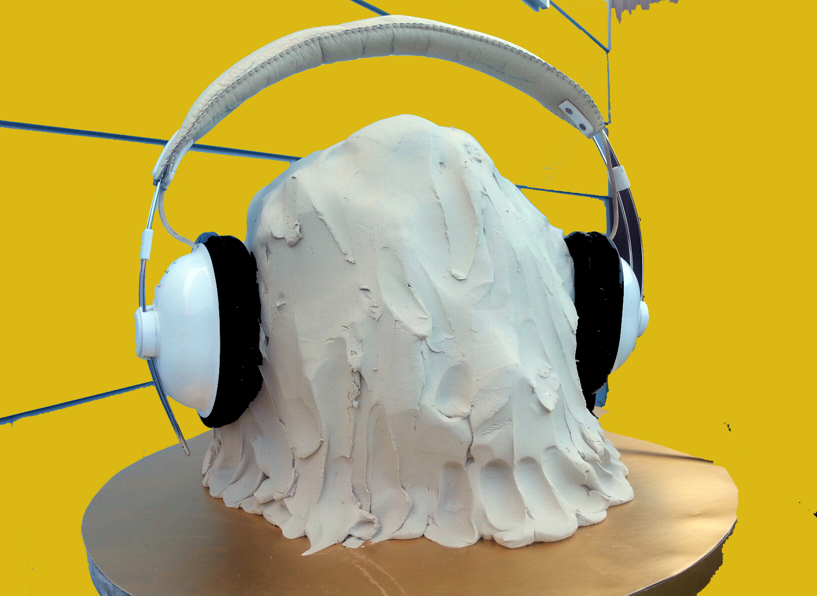 A lump of white clay loosely shaped in the outline of a human head. This is re-affirmed by large white headphones affixed on the blob-shaped head. This somewhat absurd image is further animated by the canary yellow background. This image was used for the call out to participants