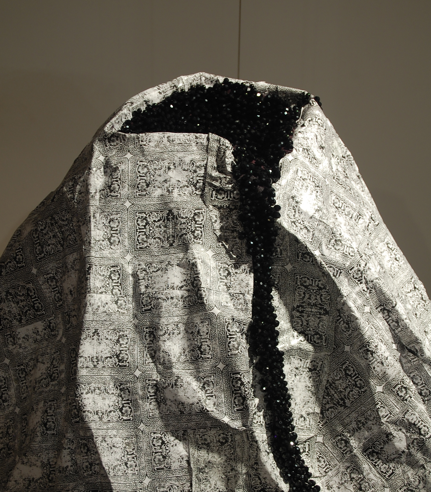 Detail view of the top of the volcano sculpture. Here you can see the black and white pattern copied from the back of Italian playing cards and the hand sewn glass beads that form clusters molten black lava