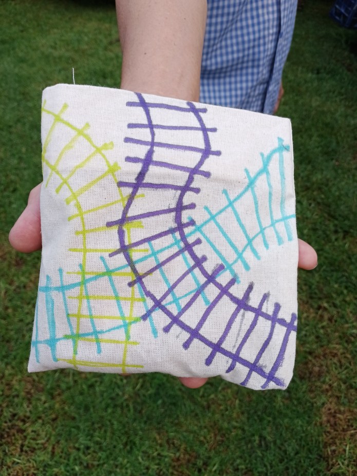 Purple, aqua and green drawing of interlocking train tracks Corn Throw by Adhi M back view